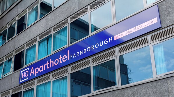 A building with a sign for 'Aparthotel Farnborough' and a website address. - HQ Aparthotel Farnborough (Farnborough)