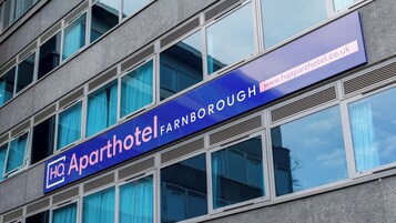 Un edificio con un letrero que indica 'Aparthotel Farnborough' y una dirección web.