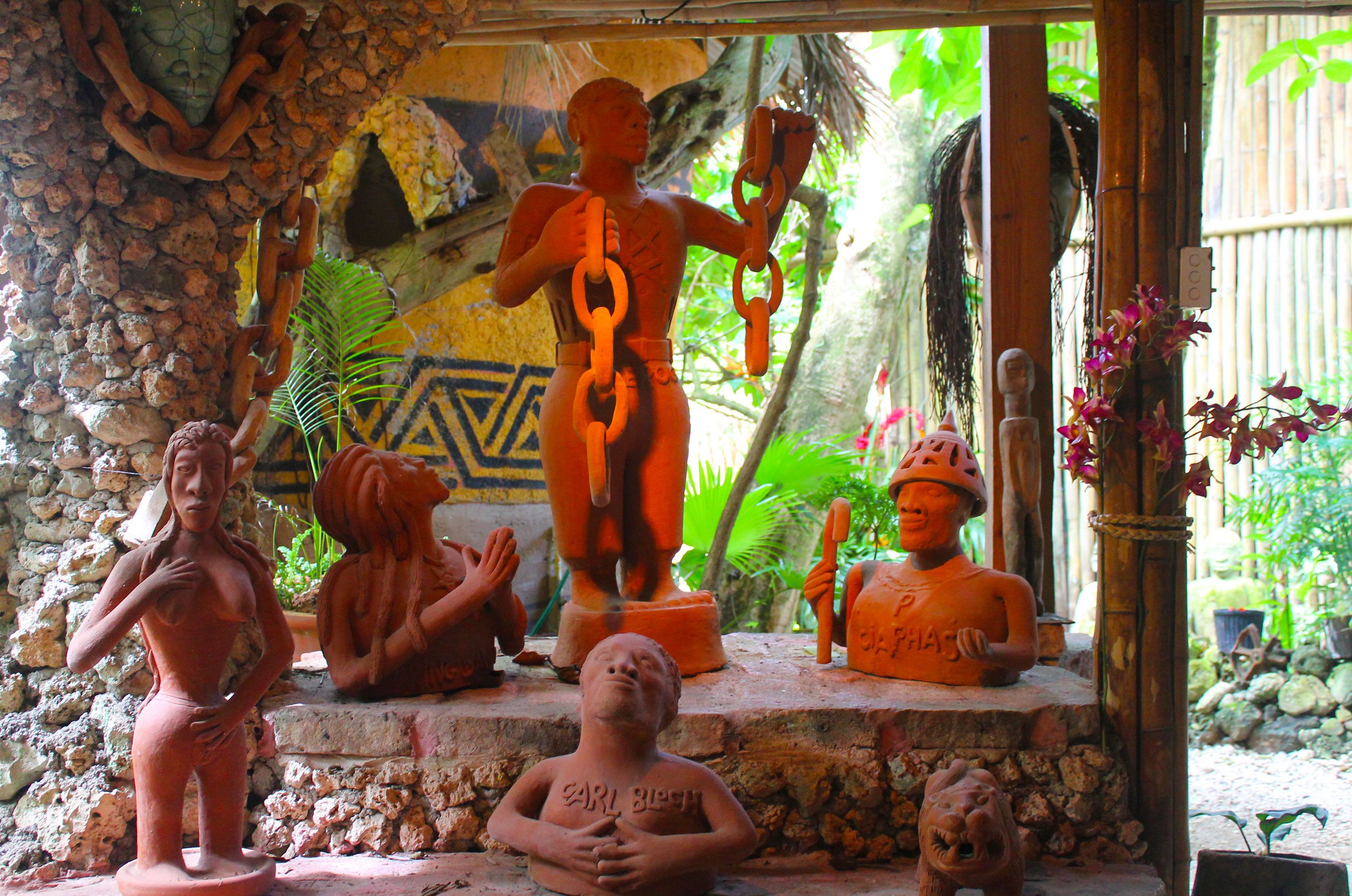 Une collection de sculptures en terre cuite, exposée dans un jardin.