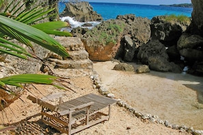 Privat strand, hvit sand, solsenger og strandhåndklær