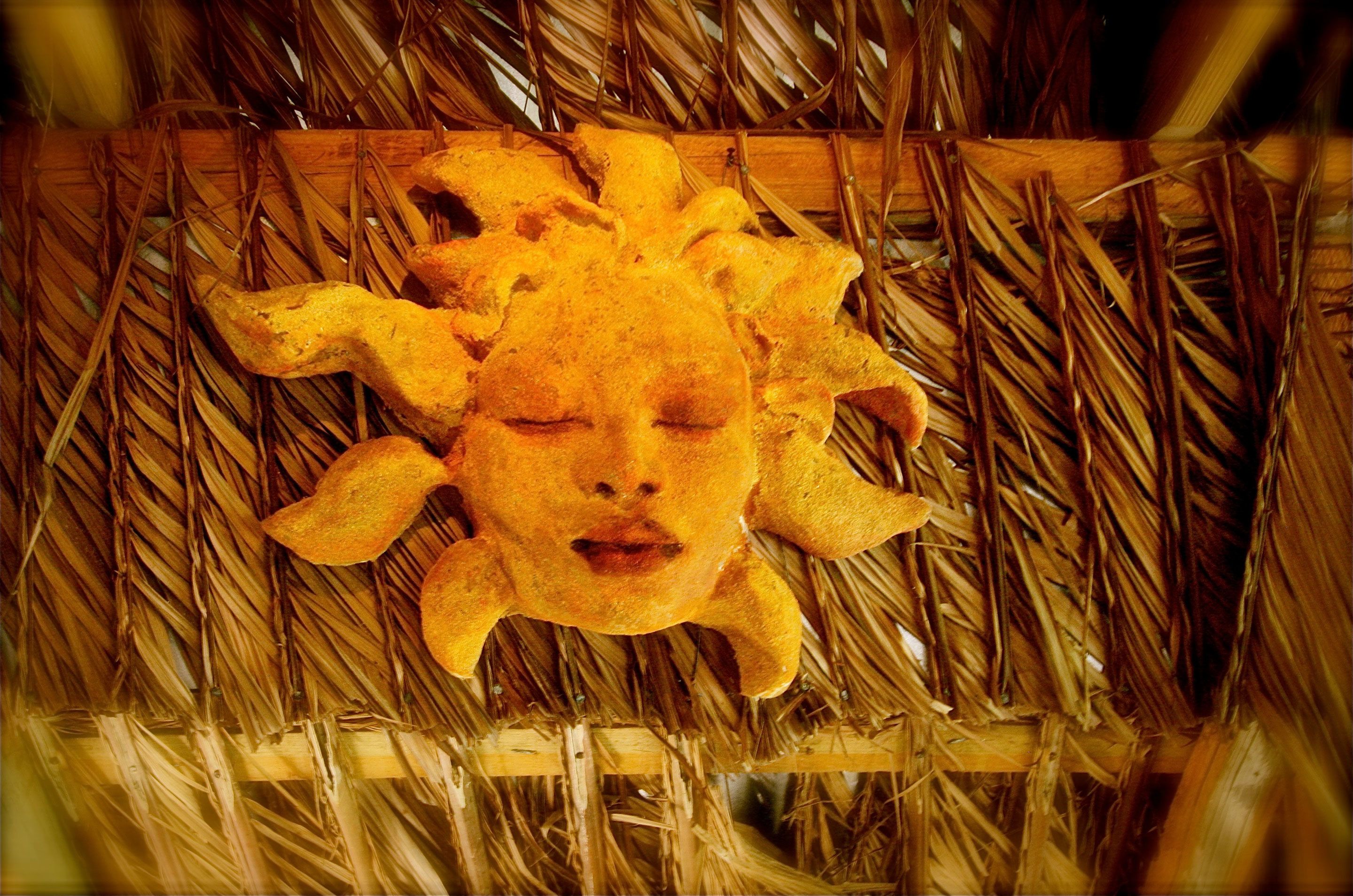 A decorative sun-like structure made of straw, surrounded by straw.