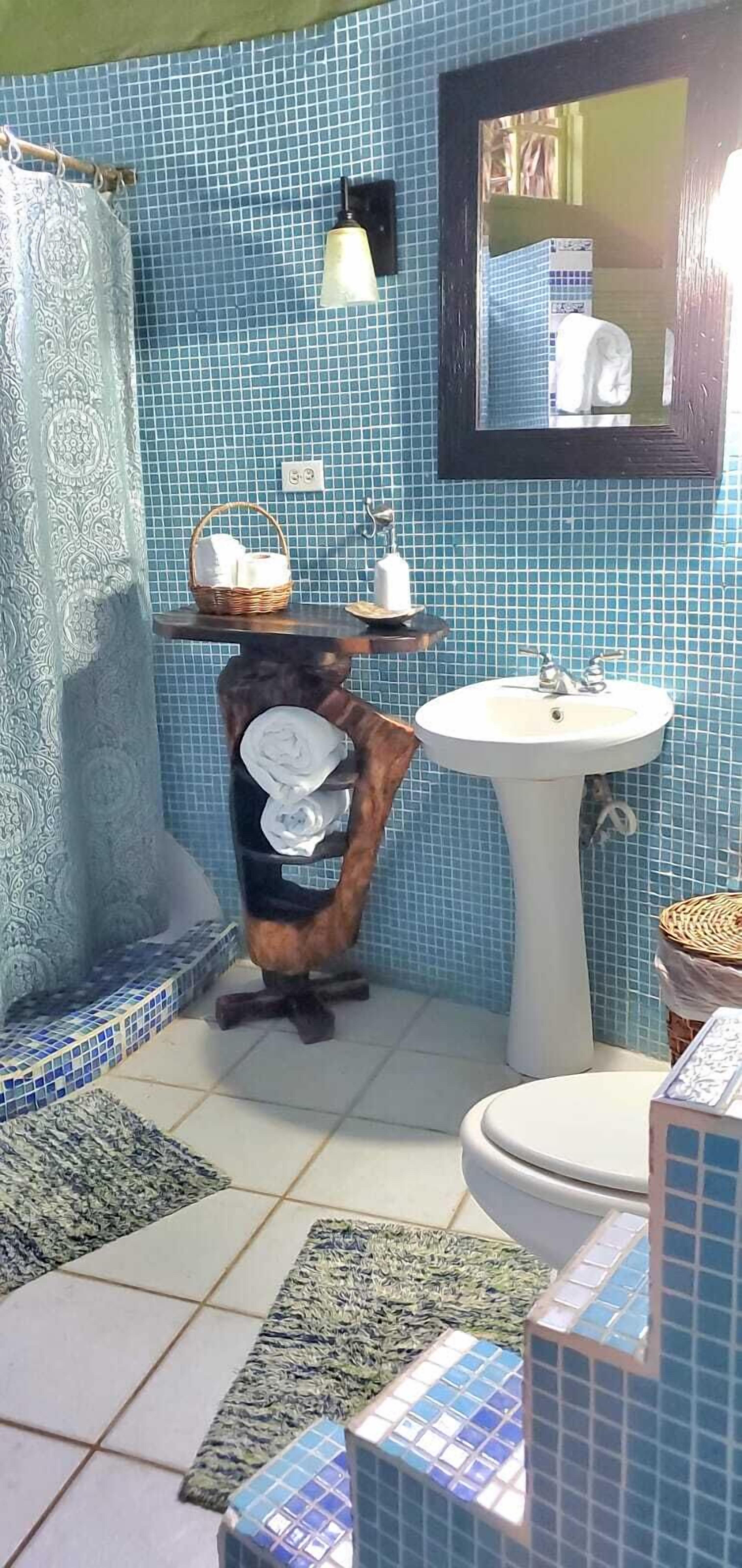 Un baño con lavamanos, inodoro y espejo.