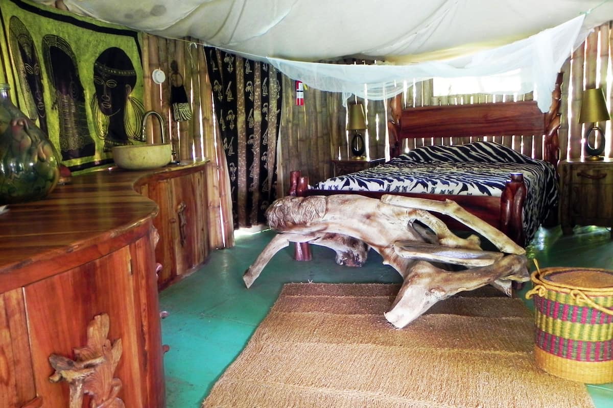 A room with a bed, wooden furniture, and a large animal skull.