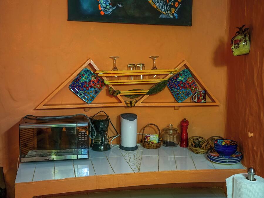 A kitchen counter with a microwave, coffee maker, and various kitchen items.