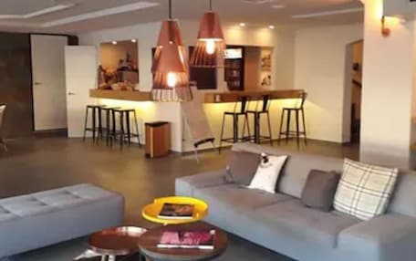 A modern living room with a sofa, coffee table, and pendant lights.