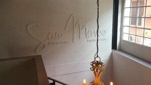 L’intérieur d’un hôtel, avec une enseigne indiquant « San Marino Hotel & Caffè » et un lustre orné de bougies allumées.