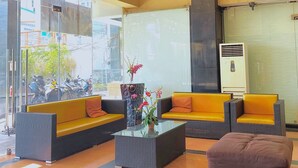 A reception area with wicker furniture, a glass coffee table, and a potted plant. - The Orchard Cebu Hotel & Suites powered by Cocotel (Mandaue)
