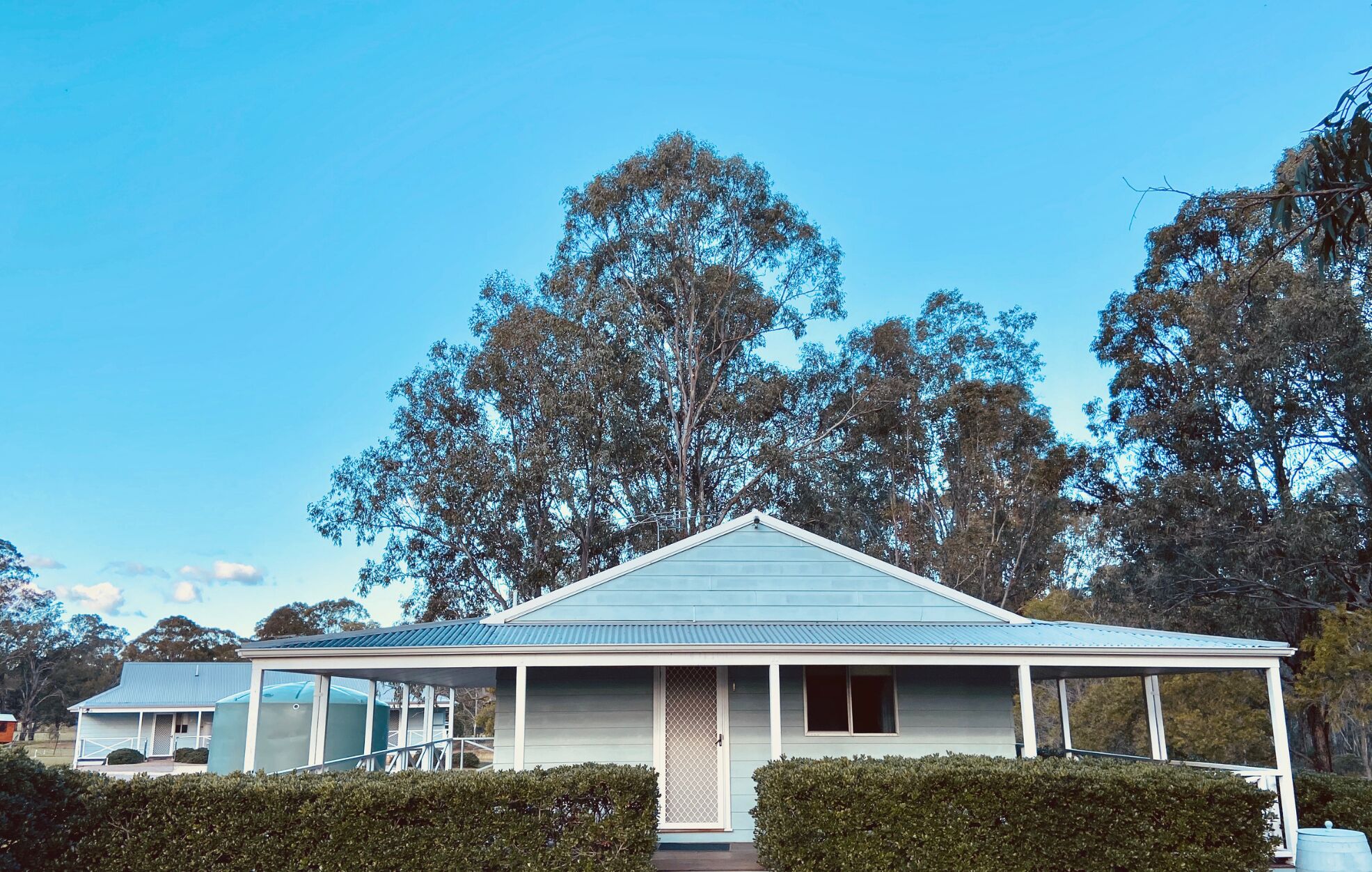 A single-story house with a gabled roof, a covered porch, and a fenced yard.