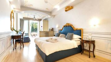 A spacious bedroom with a large bed, a small table, and a chair.