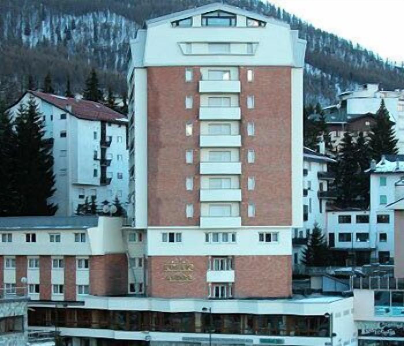 Egy többemeletes szálloda, melynek központi része vörös téglából épült, a felső szintjei pedig fehérek.