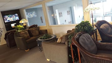 A cozy living room with a sofa, armchairs, a coffee table, and a TV.