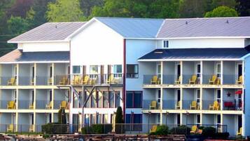 Un motel à étages, doté de balcons et situé sur une côte rocheuse.
