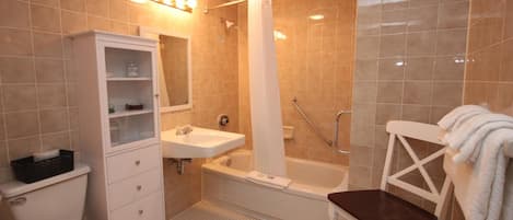 Un baño equipado con inodoro, lavamanos, bañera, ducha y un armario.