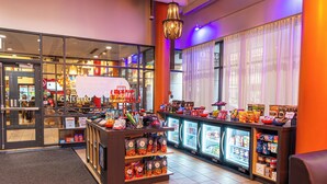 A brightly lit convenience store with refrigerated sections and a variety of snacks and beverages.