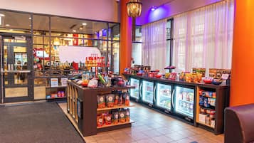 Una tienda de conveniencia muy iluminada con secciones refrigeradas y una gran variedad de aperitivos y bebidas.