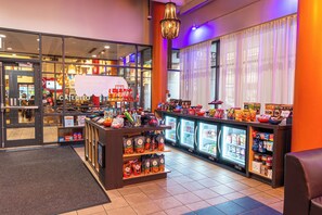 A brightly lit convenience store with refrigerated sections and a variety of snacks and beverages.