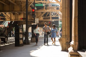 Escena de calle con semáforo, señal de 'Solo un sentido' y peatones caminando.