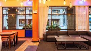 A modern lobby with a wooden reception desk, a leather sofa, and hanging light fixtures. - HI Chicago Hostel (Chicago)
