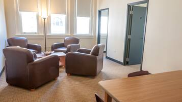 A room with a large window, a door, and a wooden table.