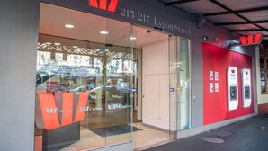 A Carlton hotel entrance with a glass door, a red awning, and a contact number above the door.