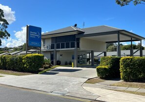 A hotel with a reception area, covered parking, and a clear sky. - Hunter Gateway Motel (Rutherford)