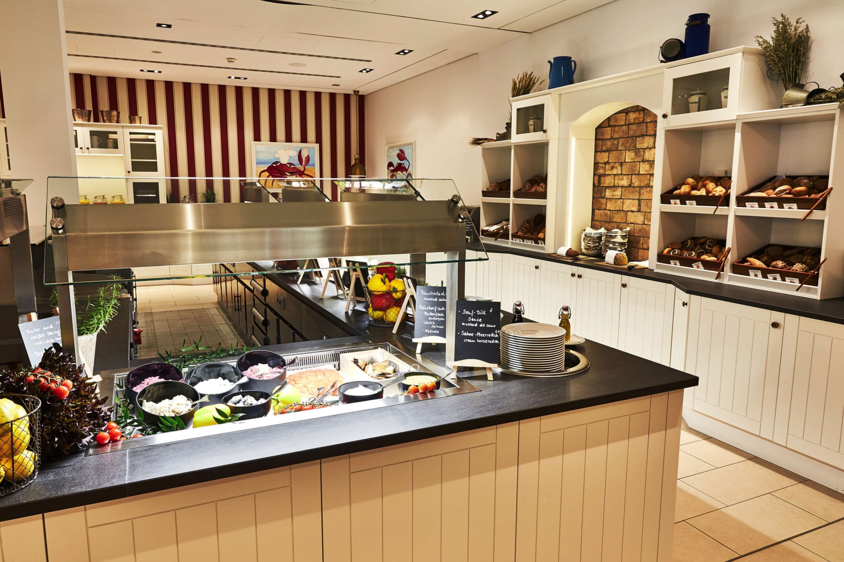 A buffet area with various food items and a sign indicating breakfast options.