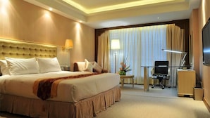 A hotel room with a large bed, a desk with a computer, and a TV. - Vili International Hotel (Guangzhou)
