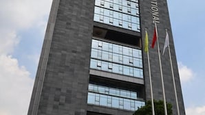 A tall building with multiple floors, featuring a large glass facade and a sign that reads "MI INTERNATIONAL". - Vili International Hotel (Guangzhou)