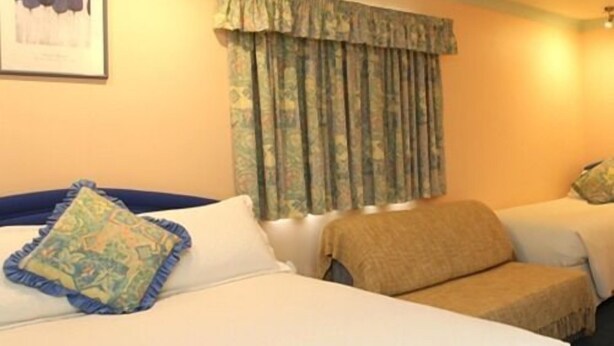 A hotel room with two beds, a large window with curtains, and a framed picture on the wall. - Little Bullocks Farm (Bishop's Stortford)
