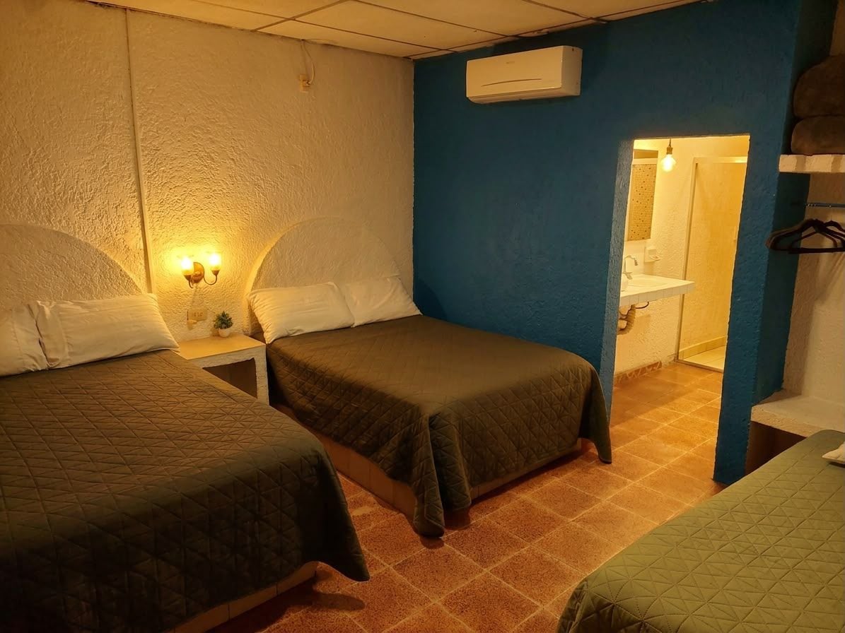 Een hotelkamer met twee bedden, een badkamer en een spiegel.