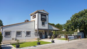 A building with a sign reading "SENZO Pizzeria - Grill" and a sign for "BRIT HOTEL" nearby. - Brit Hotel Confort Manosque Cadarache (Manosque)