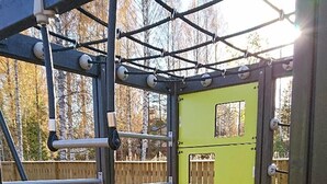Uma estrutura de recreação infantil com uma porta amarela e barras de metal.