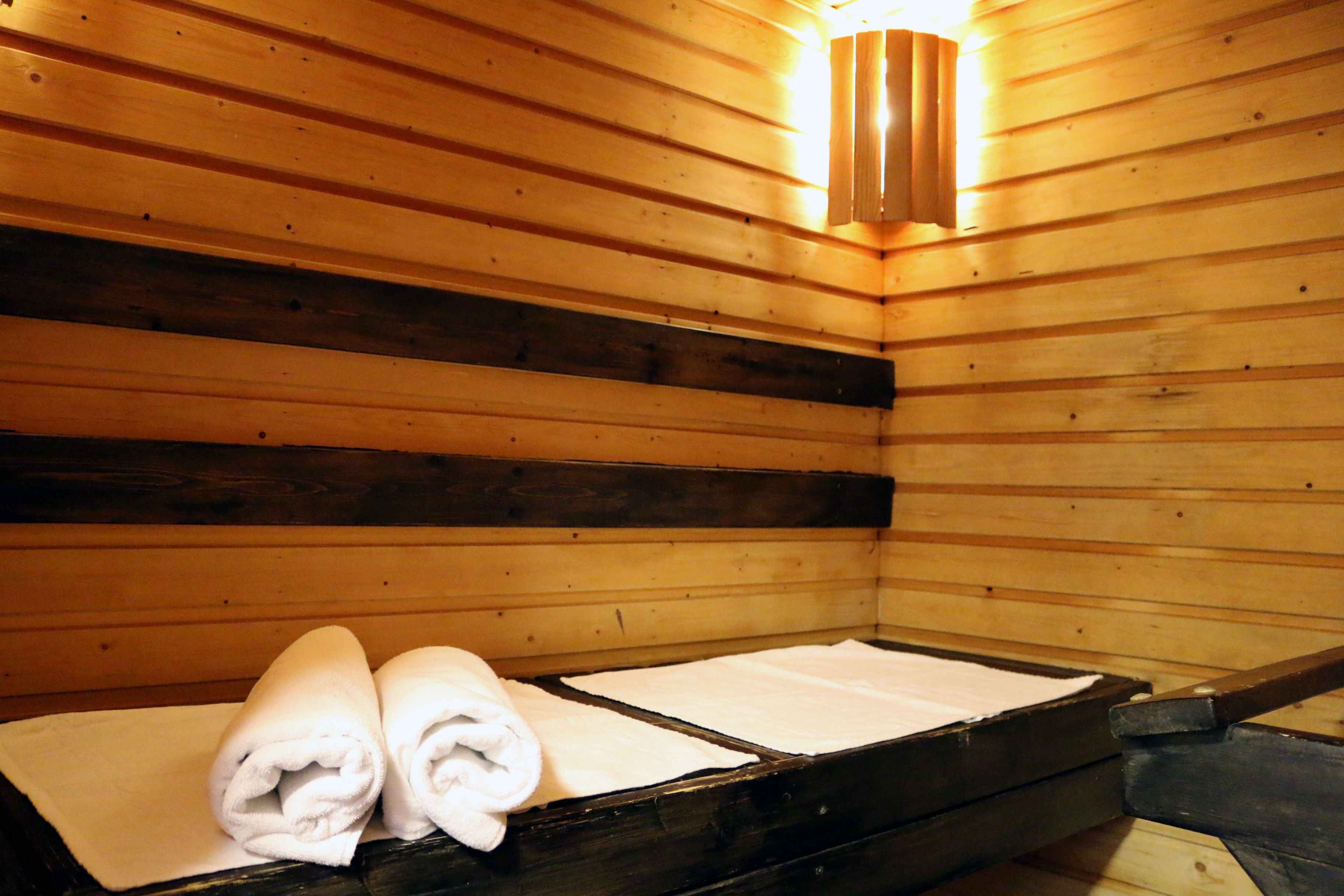 Una sauna de madera con bancos y toallas.