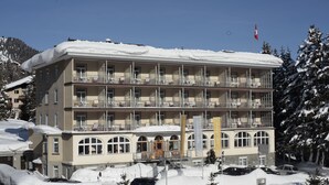 A multi-story hotel with balconies, a snow-covered roof, and a flag. - Hotel Edelweiss (Davos)
