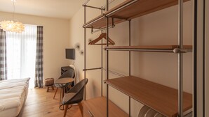 A modern room with a bed, a chair, a table, and a hanging light fixture. - Hotel Edelweiss (Davos)