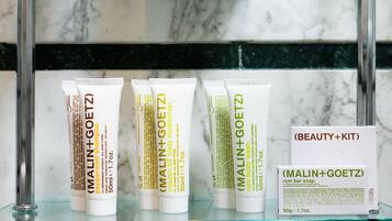 A display of MALIN+GOETZ beauty products on a glass shelf.