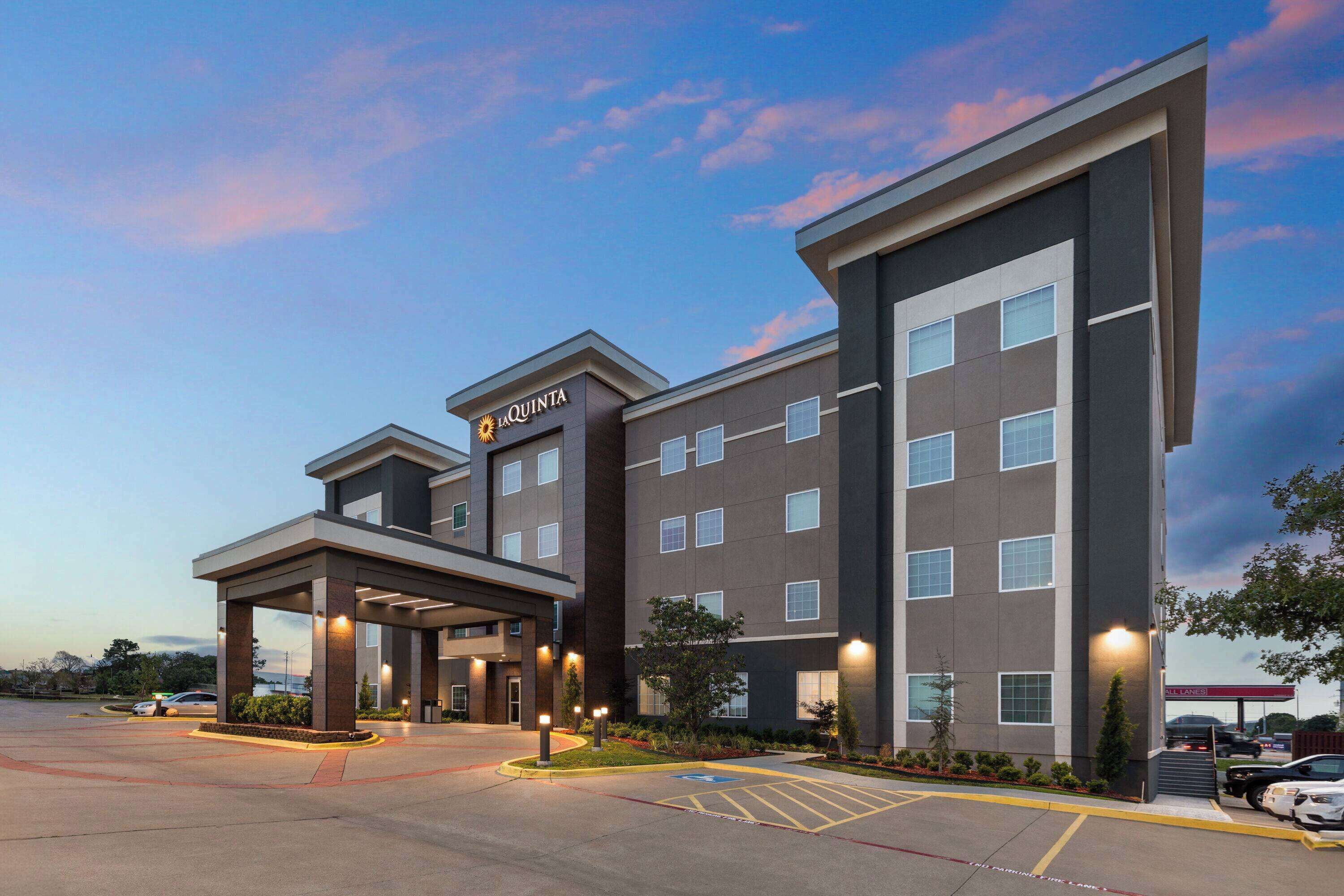 A La Quinta hotel with a modern design, featuring a covered entrance and multiple floors.