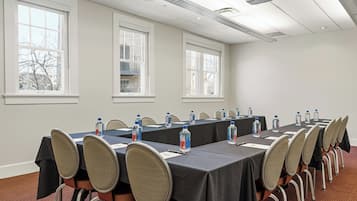 Una sala de conferencias con una mesa larga, sillas y botellas de agua.