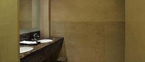 A bathroom with two sinks, a mirror, and a shower area.
