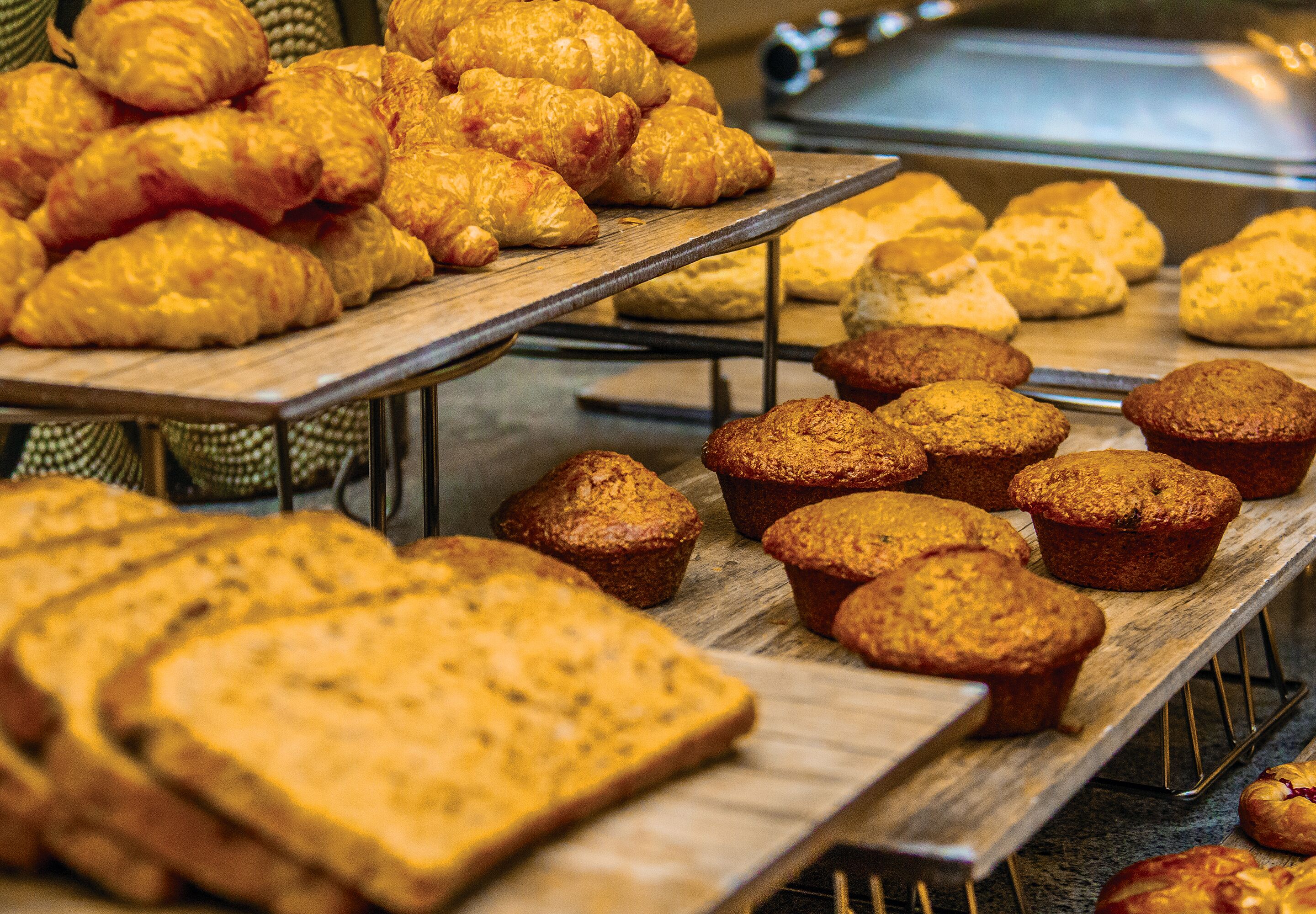 Et udvalg af friskbagte varer, herunder croissanter, muffins og brød.