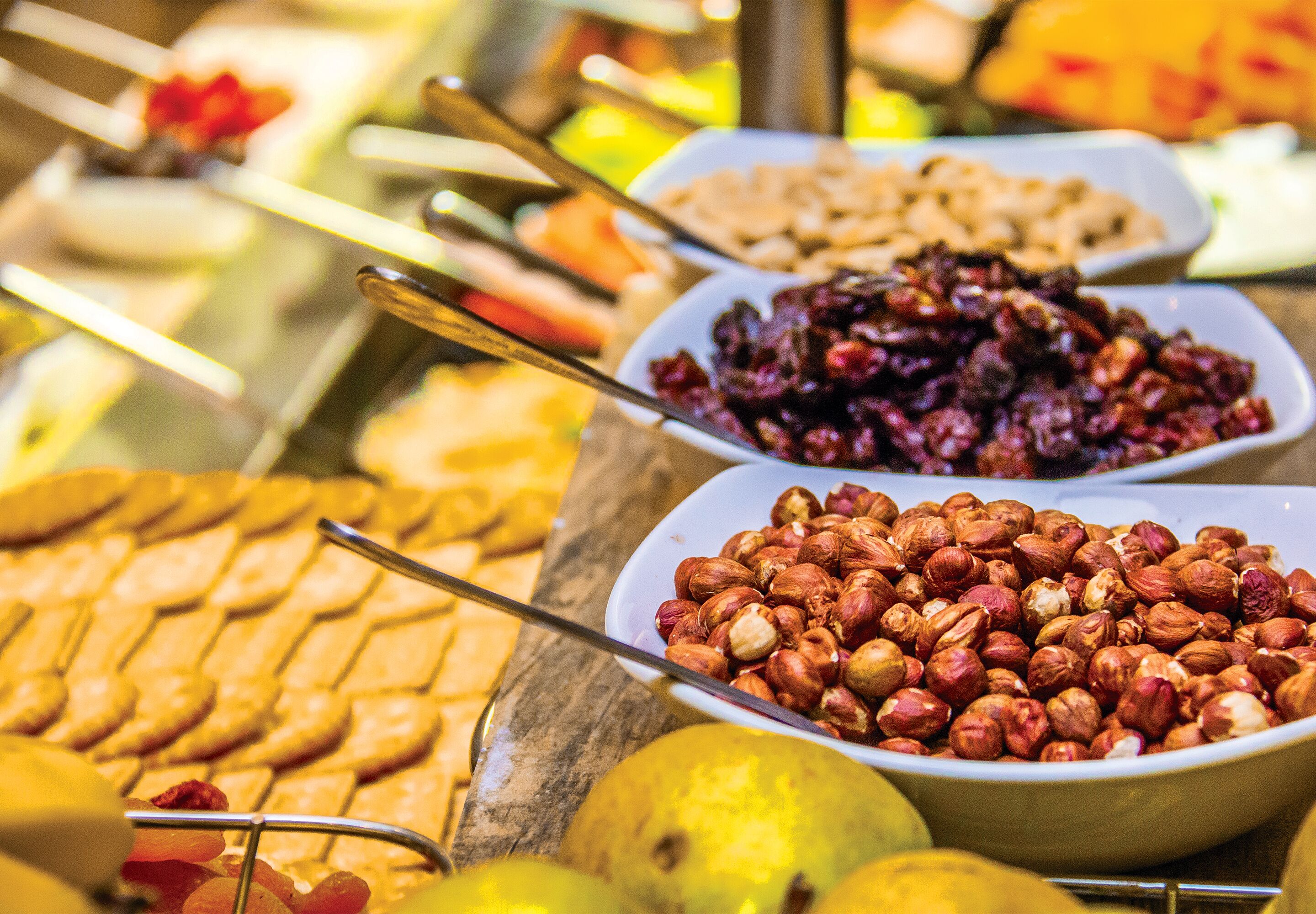 A buffet with various food items including nuts, fruits, and pastries.