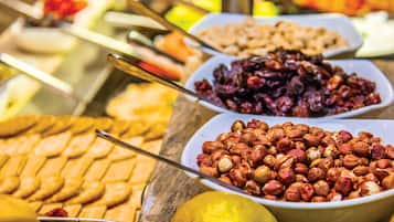 A buffet with various food items including nuts, fruits, and pastries.