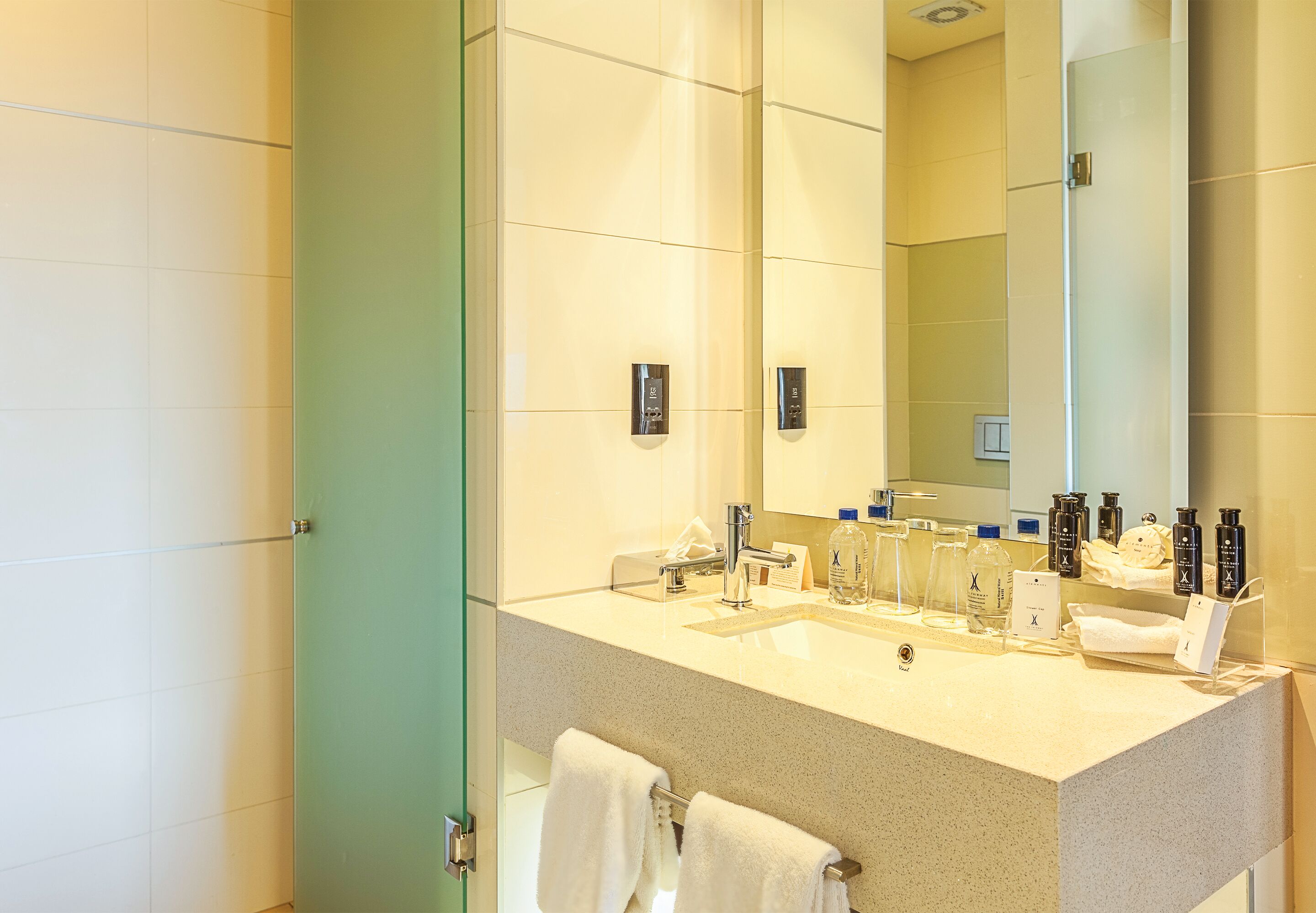 Un baño moderno con un espejo grande, un lavamanos y un perchero para toallas.
