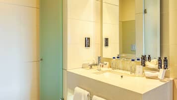 Un baño moderno con un espejo grande, un lavamanos y un perchero para toallas.