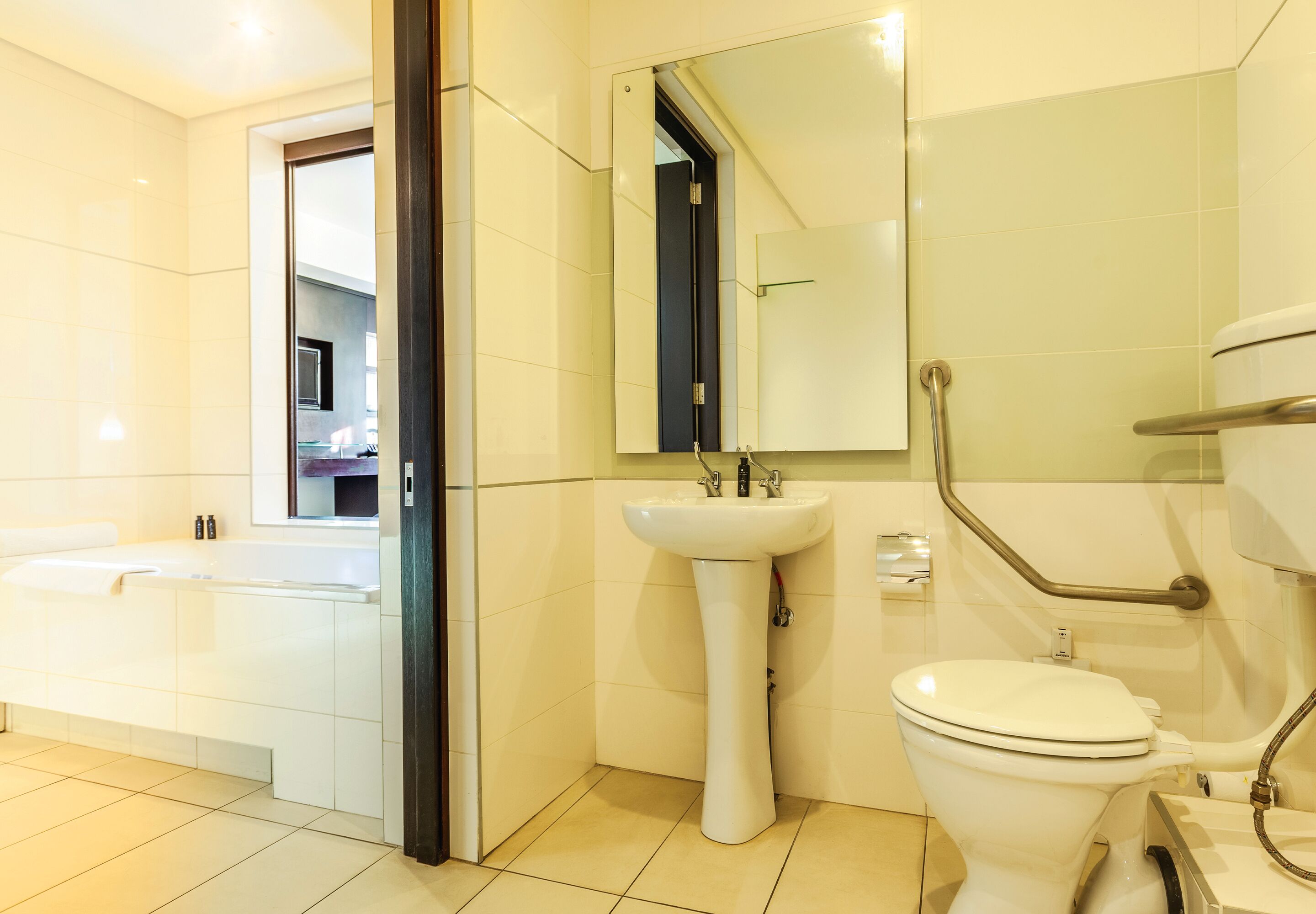 Een moderne badkamer met bad, wastafel en toilet.