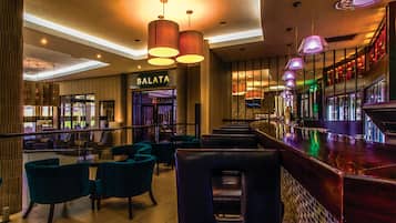 Un moderno bar con asientos de cuero e iluminación colgante.