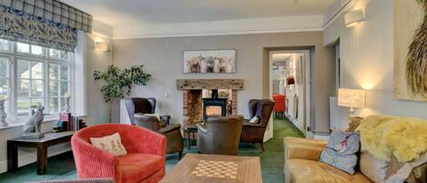 A cozy living room with leather sofas, a wooden coffee table, and a fireplace.