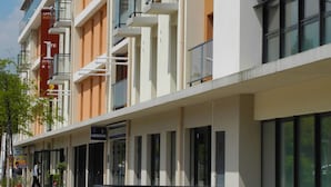 A modern multi-story hotel with balconies, a visible entrance, and signage indicating a hotel and a laboratory. - Villa Val Sénart (Quincy-sous-Senart)