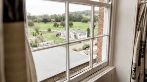 A window with a view of a brick building and a green landscape. - Sweeney Hall Hotel (Oswestry)