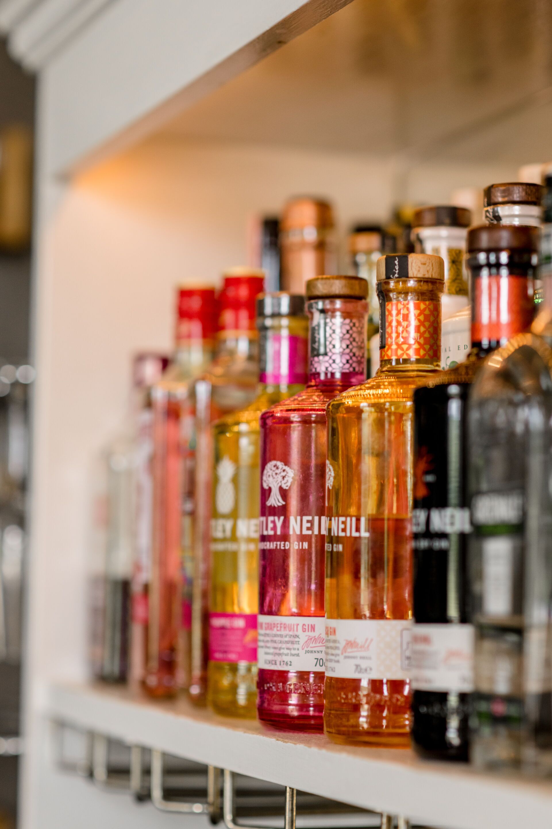 Una estantería con varias botellas de ginebra.